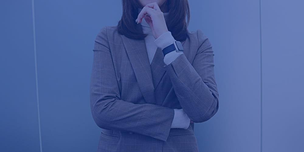 スーツを着た女性が考え事をしている